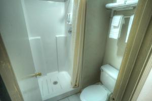 y baño pequeño con ducha y aseo. en Amerivu Inn & Suites - Helen - Downtown, en Helen