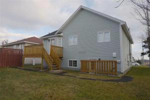 a house with a wooden deck in the yard at Two Bedroom Apartment Near St John's Airport in St. John's