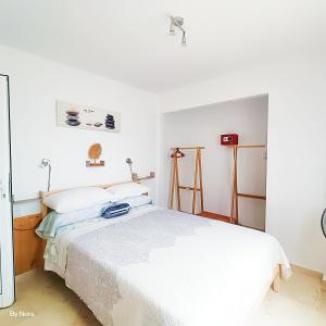 a bedroom with a large white bed in it at Apartment Las Arenas - Las Casas de Aron in Caleta De Fuste