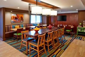 a dining room with a large wooden table and chairs at Fairfield Inn by Marriott Rochester East in Webster