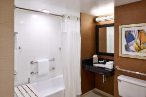 uma casa de banho com um chuveiro, um WC e um lavatório. em Fairfield Inn by Marriott Rochester East em Webster