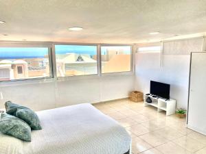 um quarto com uma cama e uma televisão de ecrã plano em Heart and Soul Apartment em San Miguel de Abona