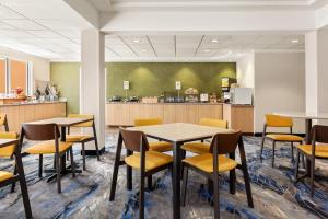 a dining room with tables and chairs and a kitchen at Fairfield Inn & Suites by Marriott Reno Sparks in Sparks