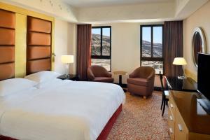a hotel room with a bed and a television at Petra Marriott Hotel in Wadi Musa