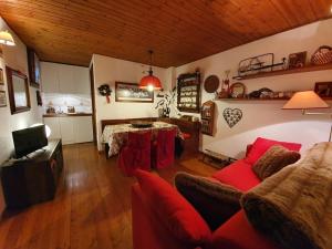 a living room with a red couch and a table at Maison Courmayeur in Verrand