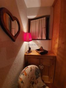 a bedroom with a table with a lamp and a chair at Maison Courmayeur in Verrand