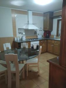 a kitchen with a table and chairs and a stove at Querido, Vamos de Férias! in Vagos