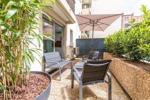 une terrasse avec des chaises, un parasol et des plantes dans l'établissement At home in Clermont, à Clermont-Ferrand