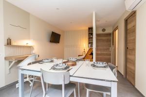 - une salle à manger blanche avec une table et des chaises blanches dans l'établissement At home in Clermont, à Clermont-Ferrand