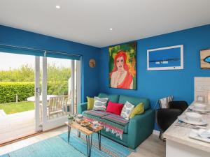a living room with blue walls and a blue couch at Blue Waters in Weymouth