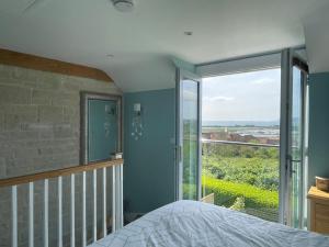 a bedroom with a bed and a large window at Blue Waters in Weymouth