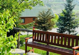 a wooden bench sitting in front of a house at Deluxe Park Qusar Resort & Spa Hotel in Qusar
