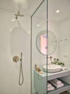 Baño blanco con lavabo y espejo en Olithos Villas, en Krotiri