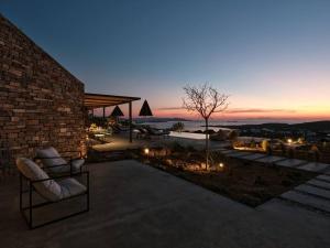 d'une terrasse avec 2 chaises et des lumières au crépuscule. dans l'établissement Olithos Villas, à Krotiri