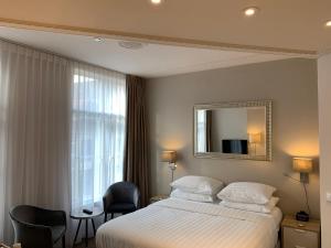 a hotel room with a bed and a mirror at Grand Canal Boutique Hotel Delft in Delft