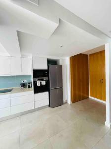 a kitchen with white cabinets and a stainless steel refrigerator at Attic apartment in old town in Denia