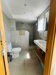 a bathroom with a toilet and a sink at Attic apartment in old town in Denia +6 photos