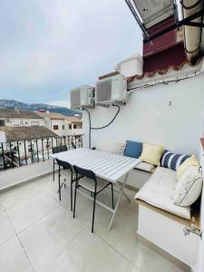 a patio with a table and chairs on a balcony at Attic apartment in old town in Denia