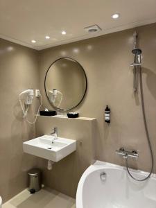 a bathroom with a sink and a mirror at Grand Canal Boutique Hotel Delft in Delft