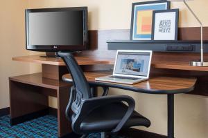 a desk with a laptop and a monitor and a chair at Fairfield Inn & Suites by Marriott Branson in Branson