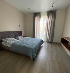 - une chambre avec un lit et une grande fenêtre dans l'établissement Панорамні апартаменти, à Oujhorod