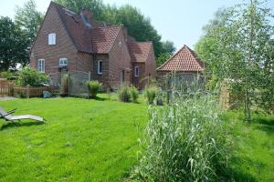 ein Haus mit einem Hof mit einem Grasfeld in der Unterkunft Altes Zollamt - Sünnschien - [#40126] in Kellenhusen