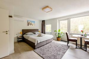 1 dormitorio con cama, escritorio y mesa en Logement viphouse Valkenburg en Valkenburg