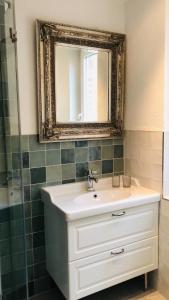 ein Bad mit einem Waschbecken und einem Spiegel in der Unterkunft Altes Zollamt - Sünnschien - [#40126] in Kellenhusen