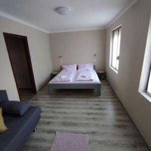 ein kleines Schlafzimmer mit einem Bett und einem Fenster in der Unterkunft Horizont Apartman Szihalom in Szihalom