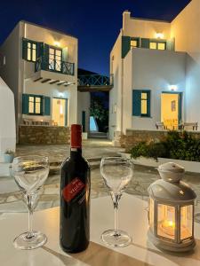 una bottiglia di vino e due bicchieri su un tavolo di Horizon Hotel a Chora Folegandros