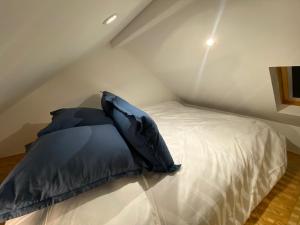 a bed with a black pillow on top of it at Tiny House Sedan in Sedan