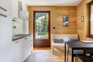 a kitchen and living room with a table and a couch at Alta Valle Maira B in Acceglio