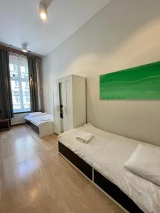 um quarto com duas camas e uma pintura verde na parede em Boutique Apartments - Elegant 1906 Period (95m2) em Breslávia