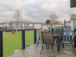 a patio with a table and chairs on a deck at Tiptoes Lodge in Carnforth