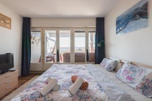 a bedroom with a bed with a view of the ocean at Apartman Cruiser in Zadar