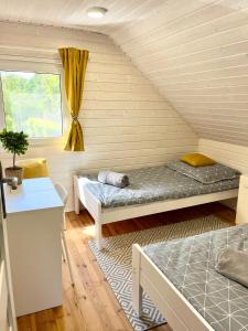 Habitación con 2 camas y ventana en Domek letniskowy Sport&Relax, en Kopalino
