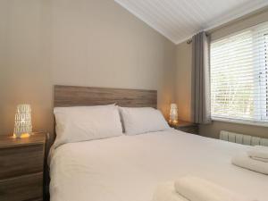 una camera da letto con un grande letto bianco e una finestra di 18 Crake Valley a Ulverston