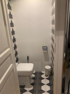 a bathroom with a toilet and a black and white floor at Tiny House Sedan in Sedan