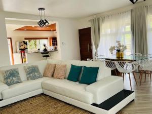 a living room with a white couch and a glass table at Casa Conforto Bilene in Vila Praia Do Bilene