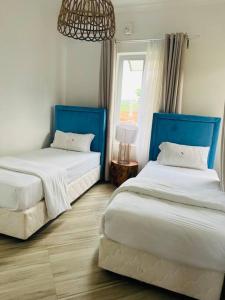 Vila Praia Do Bilene的住宿－Casa Conforto Bilene，一间卧室设有两张床和窗户。