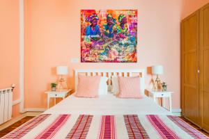 リスボンにあるBright & Beautiful Top Floor Graça Flatのベッドルーム1室(壁に絵画が描かれたベッド1台付)