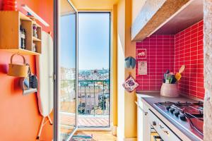 リスボンにあるBright & Beautiful Top Floor Graça Flatのピンクのタイル張りのキッチン、窓