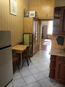 uma cozinha com uma mesa, uma mesa e um frigorífico em Cozy flat at Stadionok M station em Budapeste