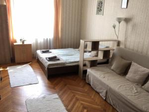 uma sala de estar com duas camas e um sofá em Cozy flat at Stadionok M station em Budapeste