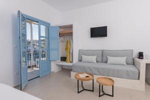 a living room with a couch and two stools at Ihthioessa Boutique Hotel in Astypalaia