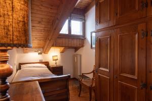a bedroom with a bed and a desk and a window at Casa Marmarole in Borca di Cadore