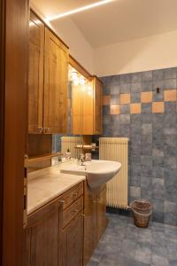 a bathroom with a sink and wooden cabinets at Casa Marmarole in Borca di Cadore