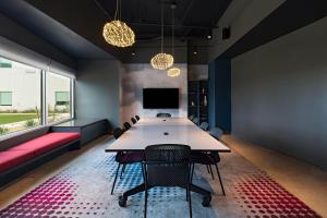 a conference room with a table and chairs and a tv at Aloft San Antonio UTSA Area in San Antonio