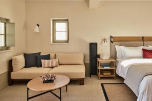 - une chambre avec un lit, un canapé et une table dans l'établissement Cosme, a Luxury Collection Resort, Paros, à Náoussa