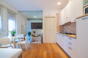 uma cozinha com uma mesa e um frigorífico branco em Dimore Verona em Verona